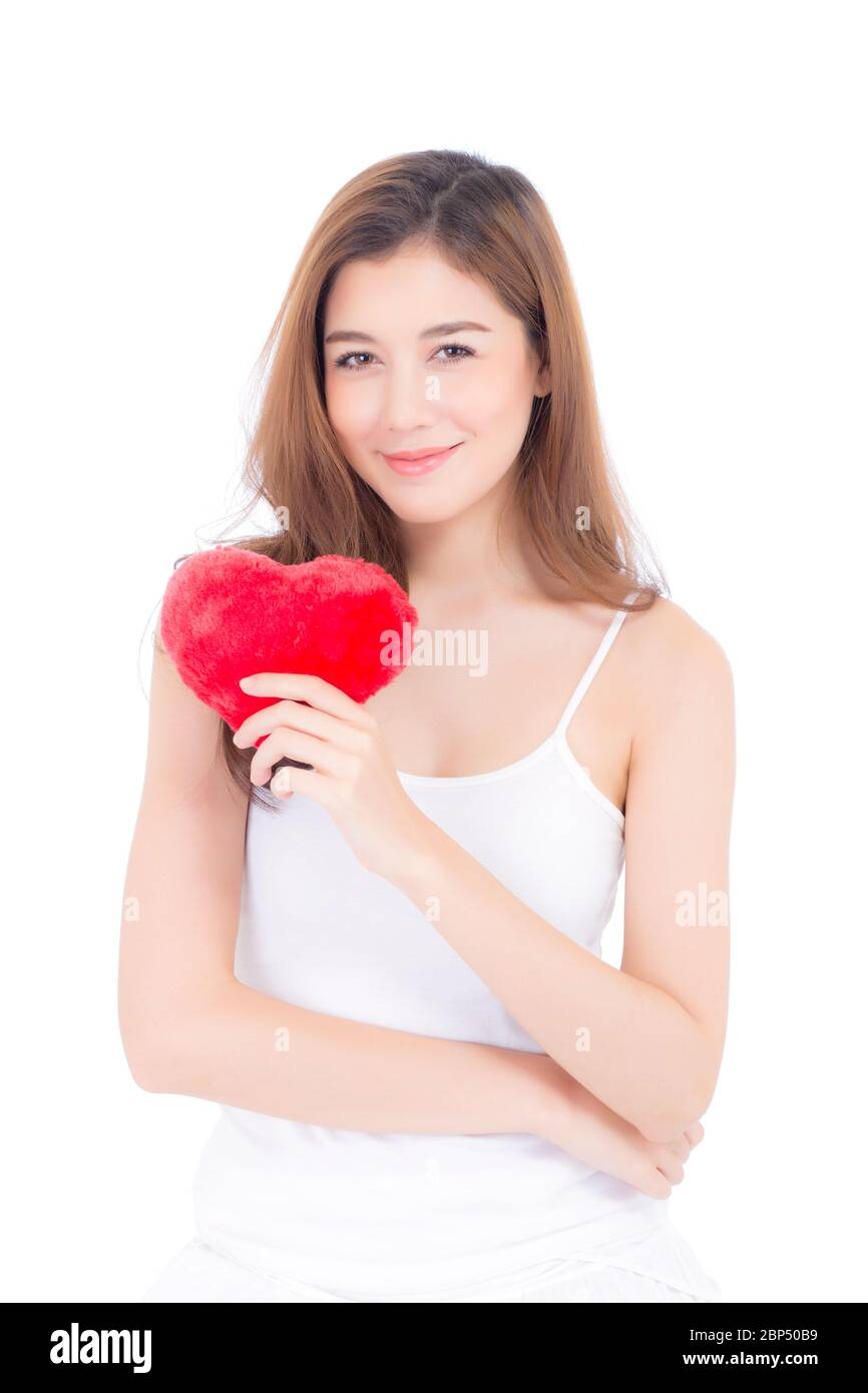 Portrait of beautiful asian young woman holding red heart shape pillow ...