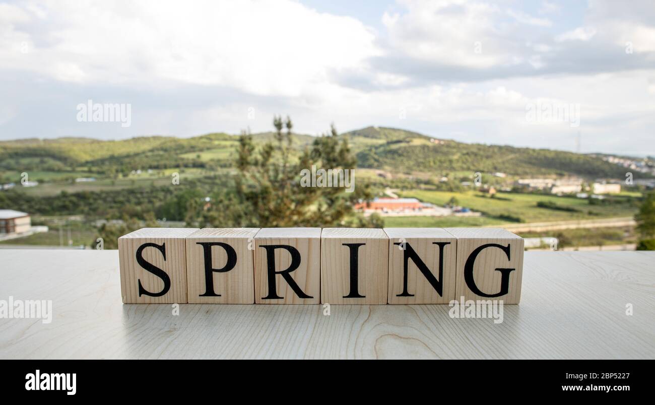 Spring, text on wooden cubes on rusty white painted iron. Stock Photo
