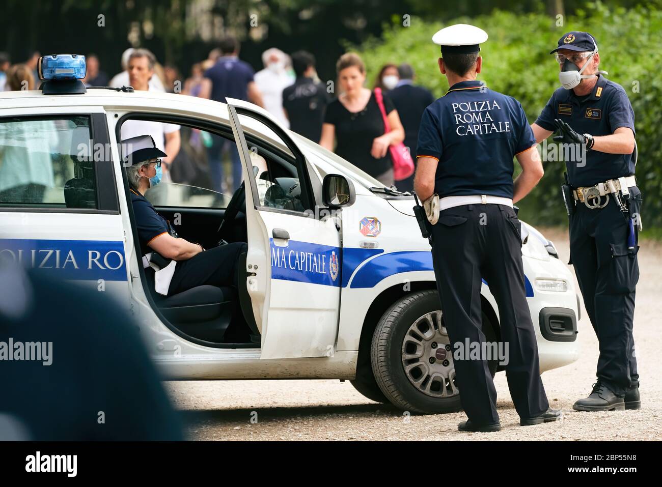 Italian Policemen Wearing Face Masks Watch People Gathering in Rome's Villa Ada City Park, as Social Distancing Measures Are Partially Lifted Stock Photo