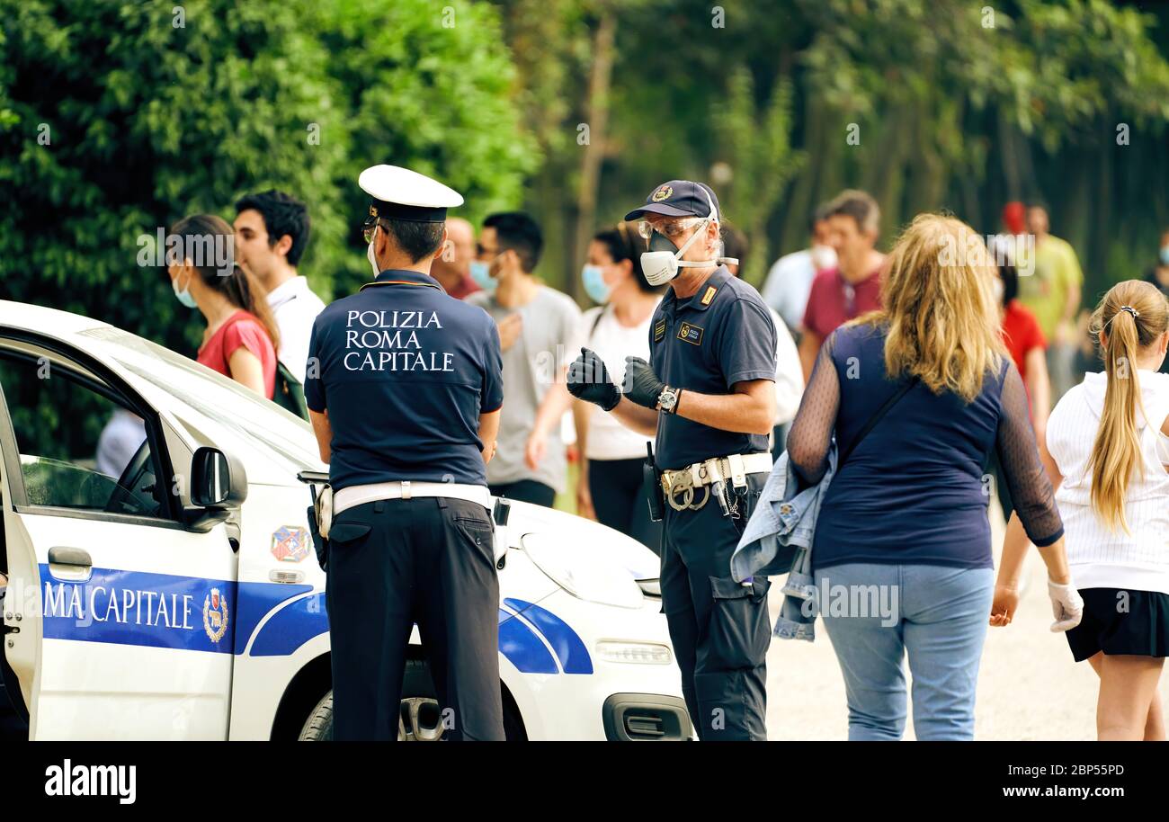 Italian Policemen Wearing Face Masks, Watching People Gathering in Rome's Villa Ada City Park as Social Distancing Measures Are Partially Eased Stock Photo
