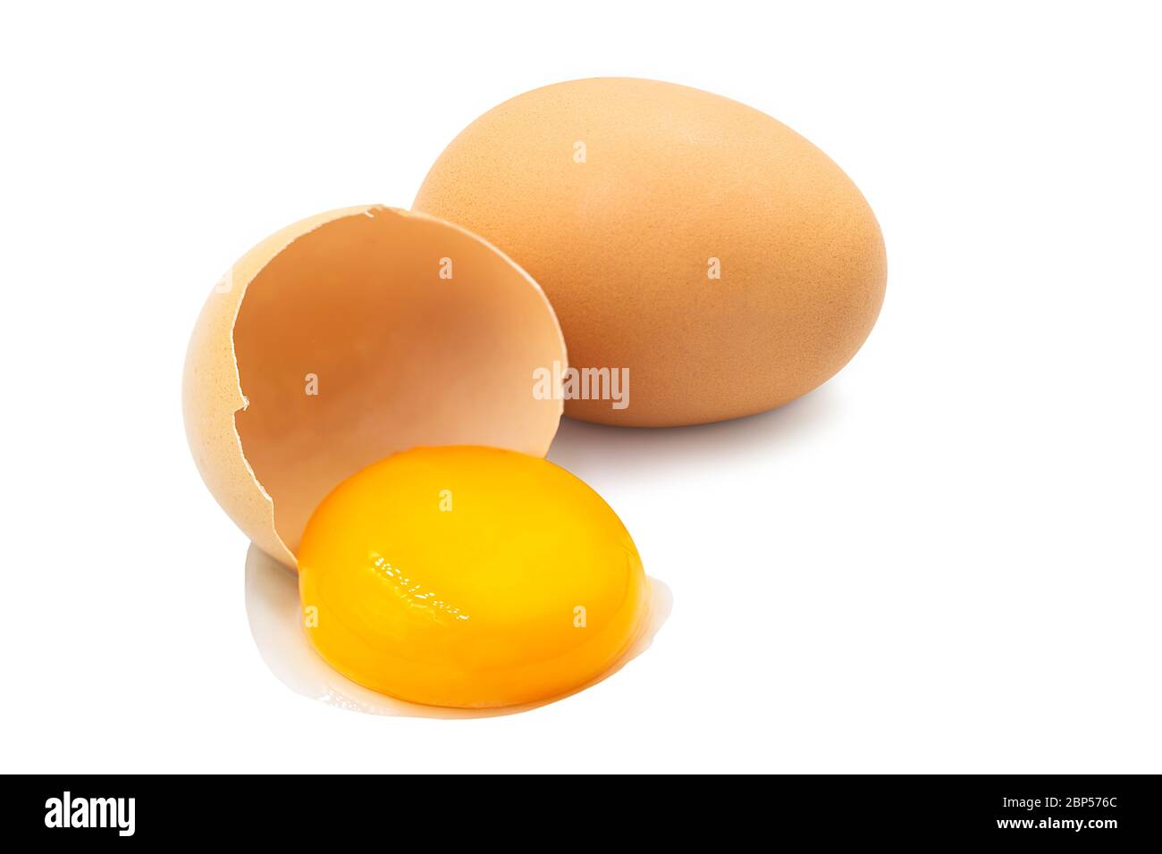 Fresh organic uncooked whole chicken egg and yolk pour from half broken