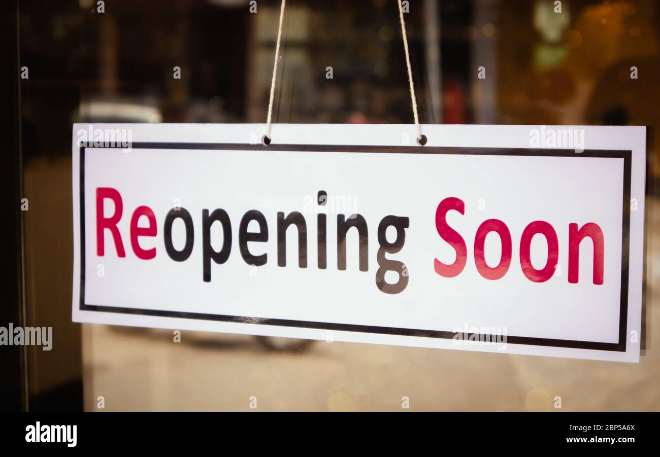 Reopening Soon Signage board in front of Businesses or Restaurant door after covid-19 or coronavirus outbreak - Concept of back to business after Stock Photo