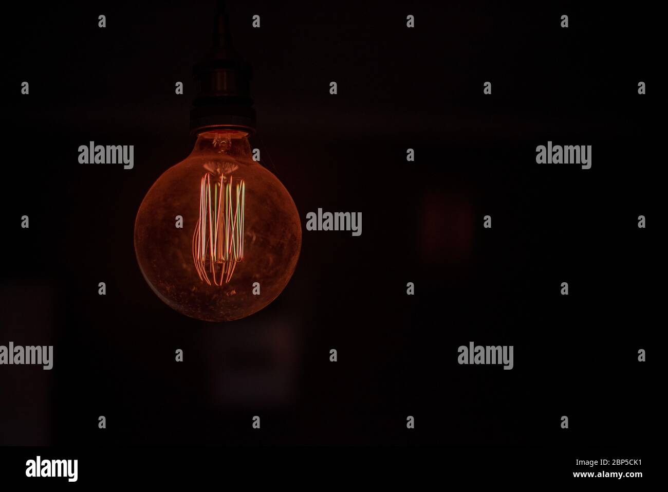 Light bulb glowing in dark room Stock Photo Alamy