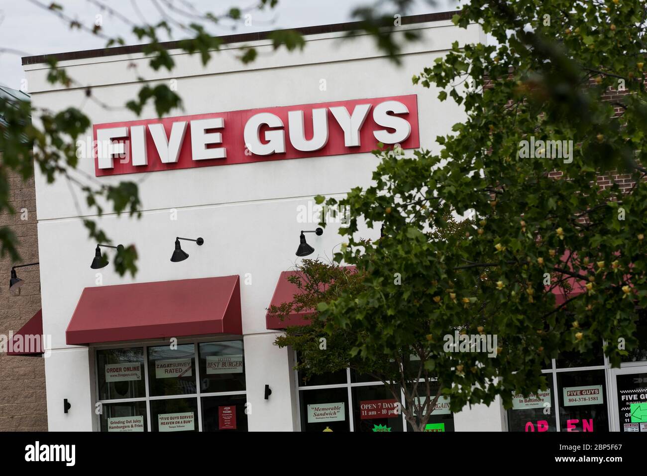 A logo sign outside of a Five Guys restaurant location in Richmond