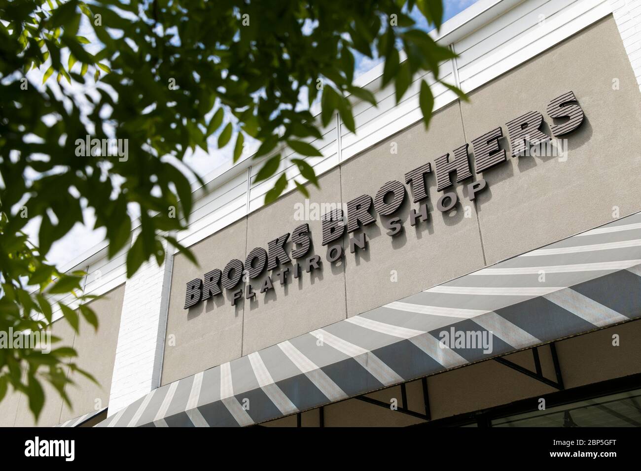 A logo sign outside of a Brooks Brothers Flatiron Shop retail store location in Charlottesville