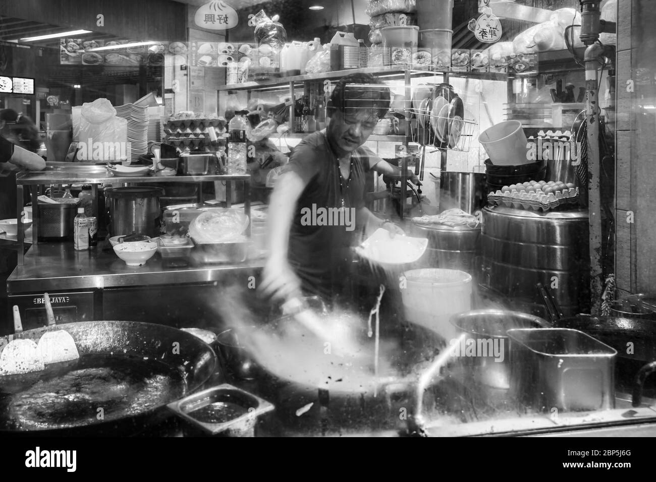 Singapore - September 07, 2019: Smiling street hawker vendor of Chinese stall in Lau Pa Sat, Telok Ayer Market hawker center, black and white Stock Photo