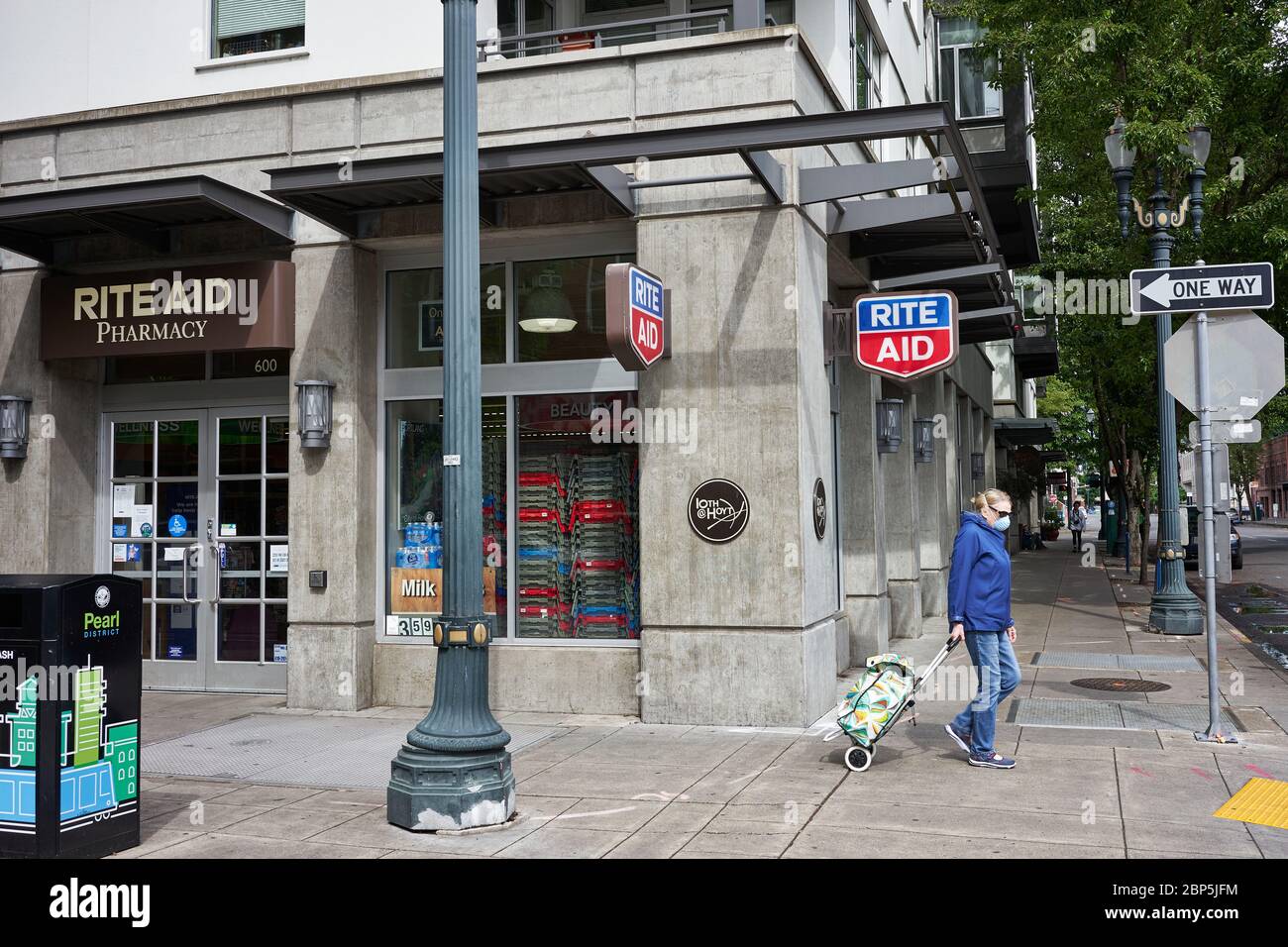 A masked elderly walks past a RITE AID pharmacy in the Pearl District of Portland, Oregon, on Friday, May 15, 2020. Stock Photo