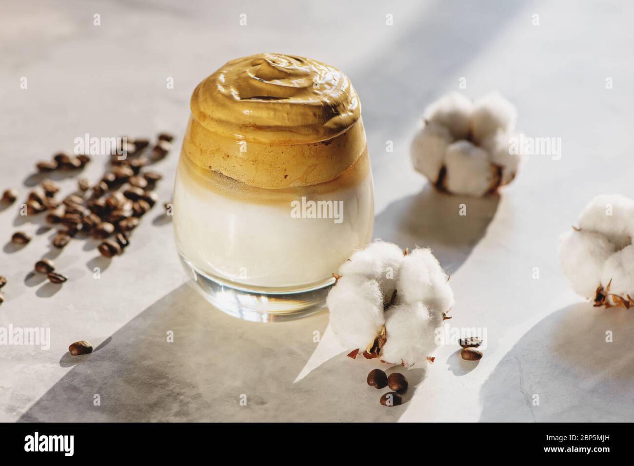 Dalgona coffee with cotton flowers on marble background close up. Stock Photo