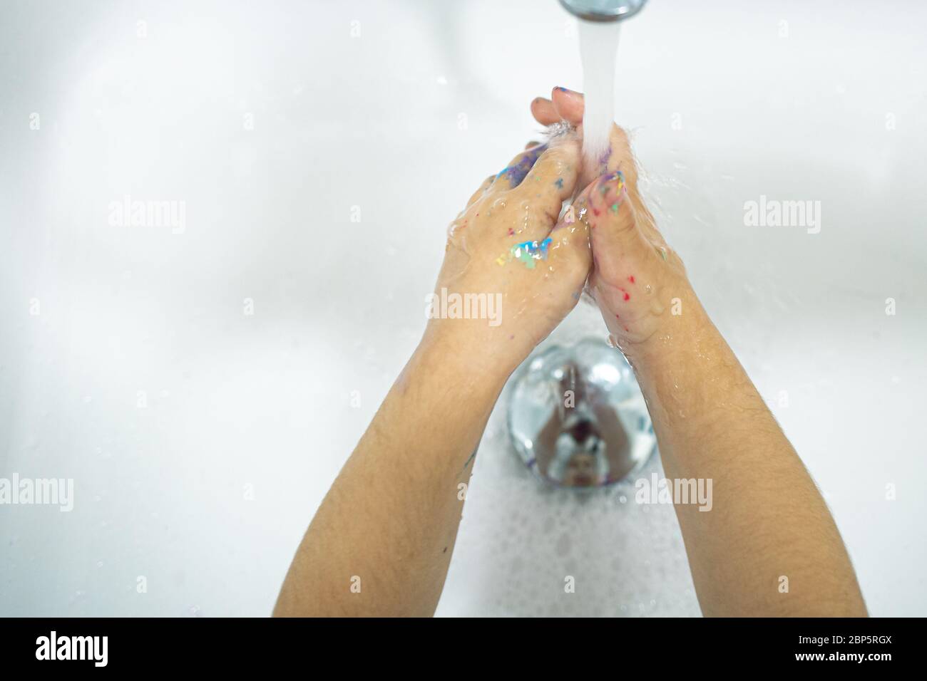 Washing hands on a white sink with water, child hands Stock Photo