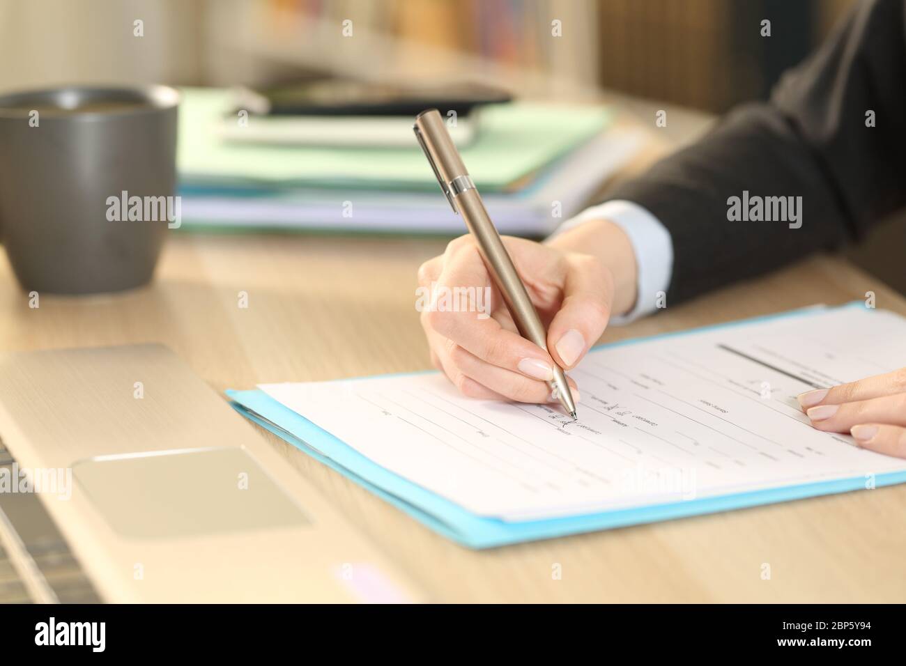 Close up of entrepreneur woman hands filling out checkbox form document sitting on a desk at home office Stock Photo