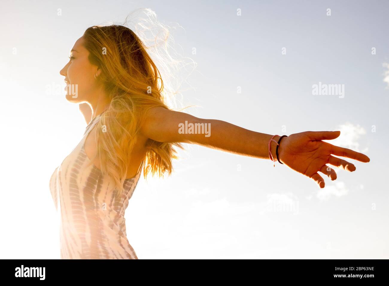 Happiness and freedom joy concept with young beautiful caucasian girl open arms and enjoy the sun - people in outdoor free activity - blonde beautiful Stock Photo
