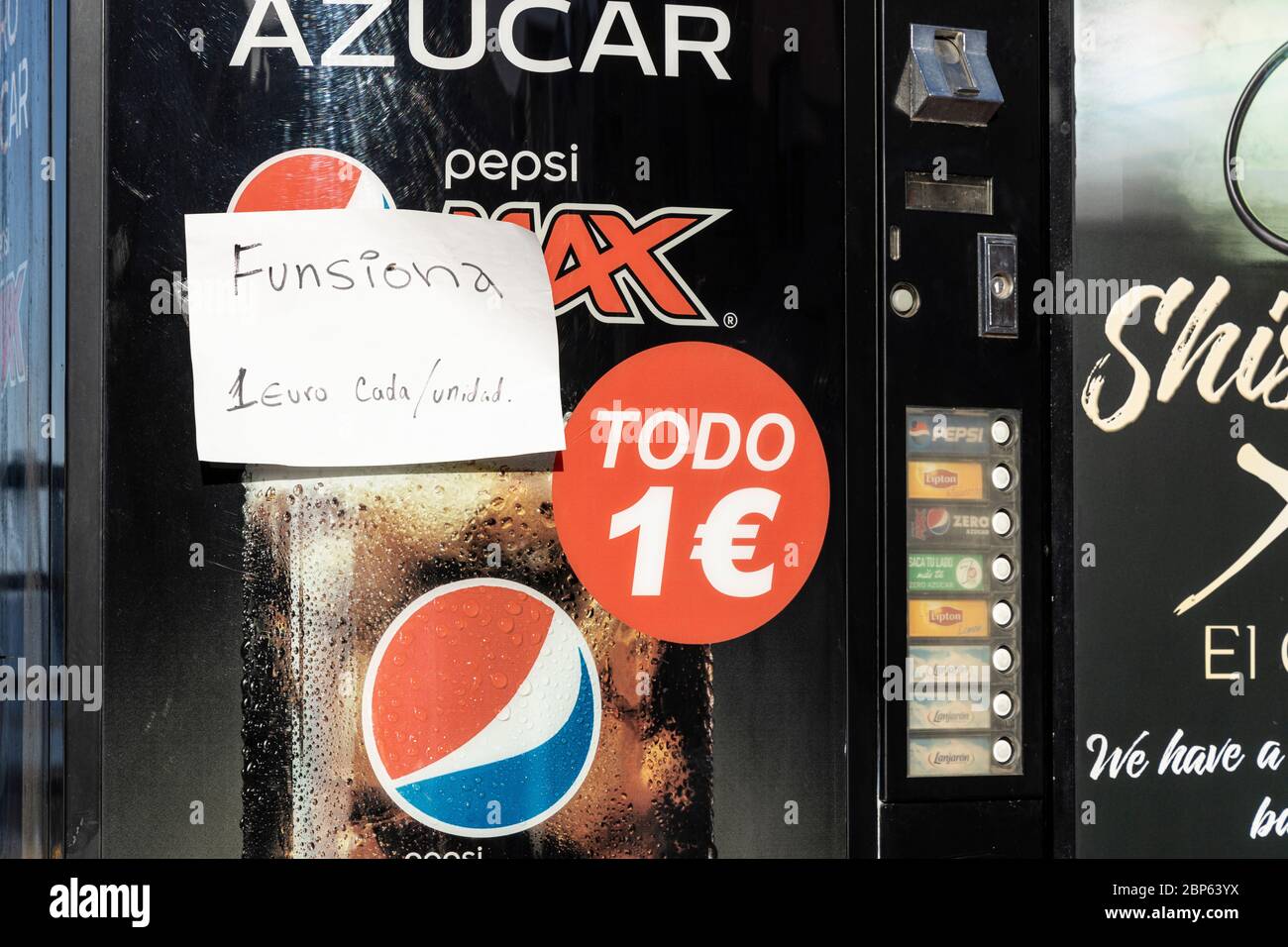 Drinks dispensing machine with hand written notice saying that it is working and each unit costs one euro, during phase one of de-escalation of the Co Stock Photo