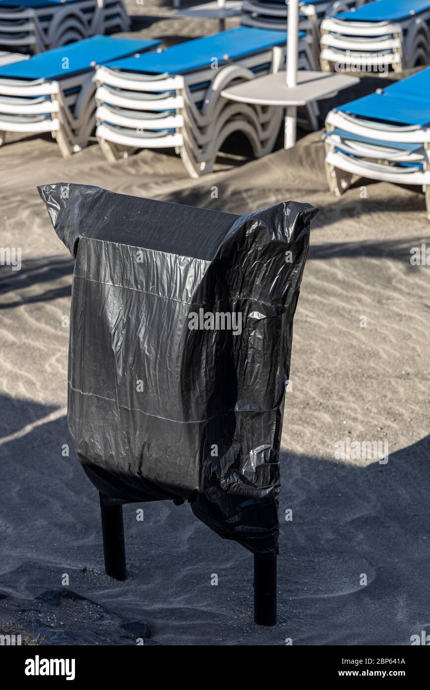 Rubbish bins sealed with a black bin bag to prevent use on Playa Fanabe, during phase one of de-escalation of the Covid 19, coronavirus, State of Emer Stock Photo