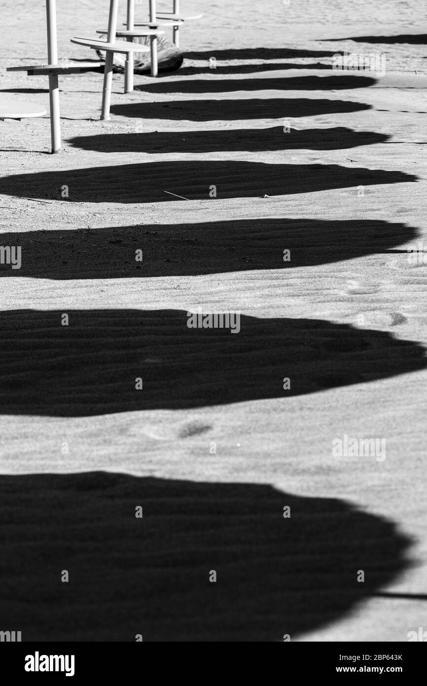Abstract images with shadows of sun umbrellas on the sand on Playa Fanabe beach during phase one of de-escalation of the Covid 19, coronavirus, State Stock Photo
