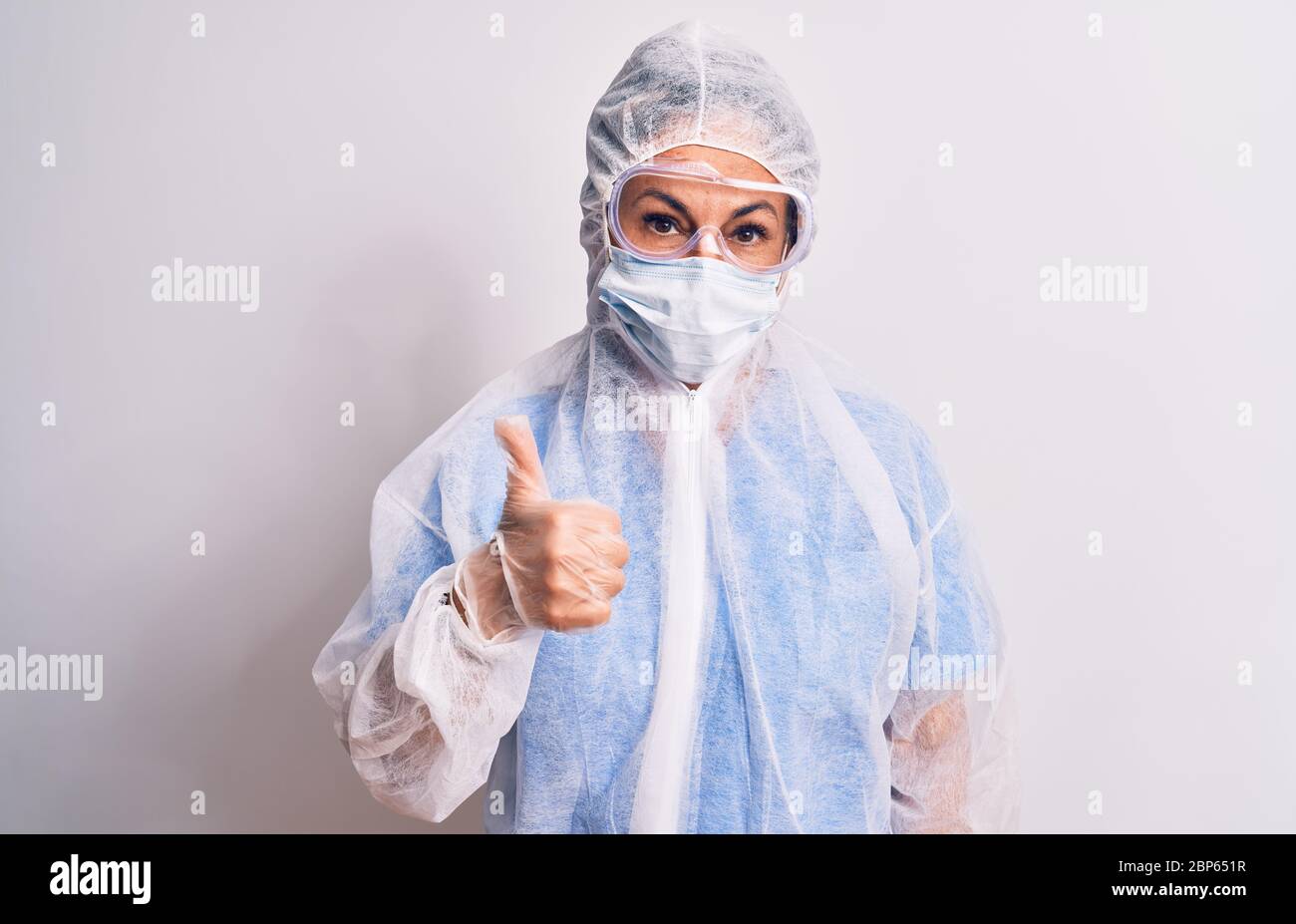 Middle age nurse woman wearing protection coronavirus equipment over ...