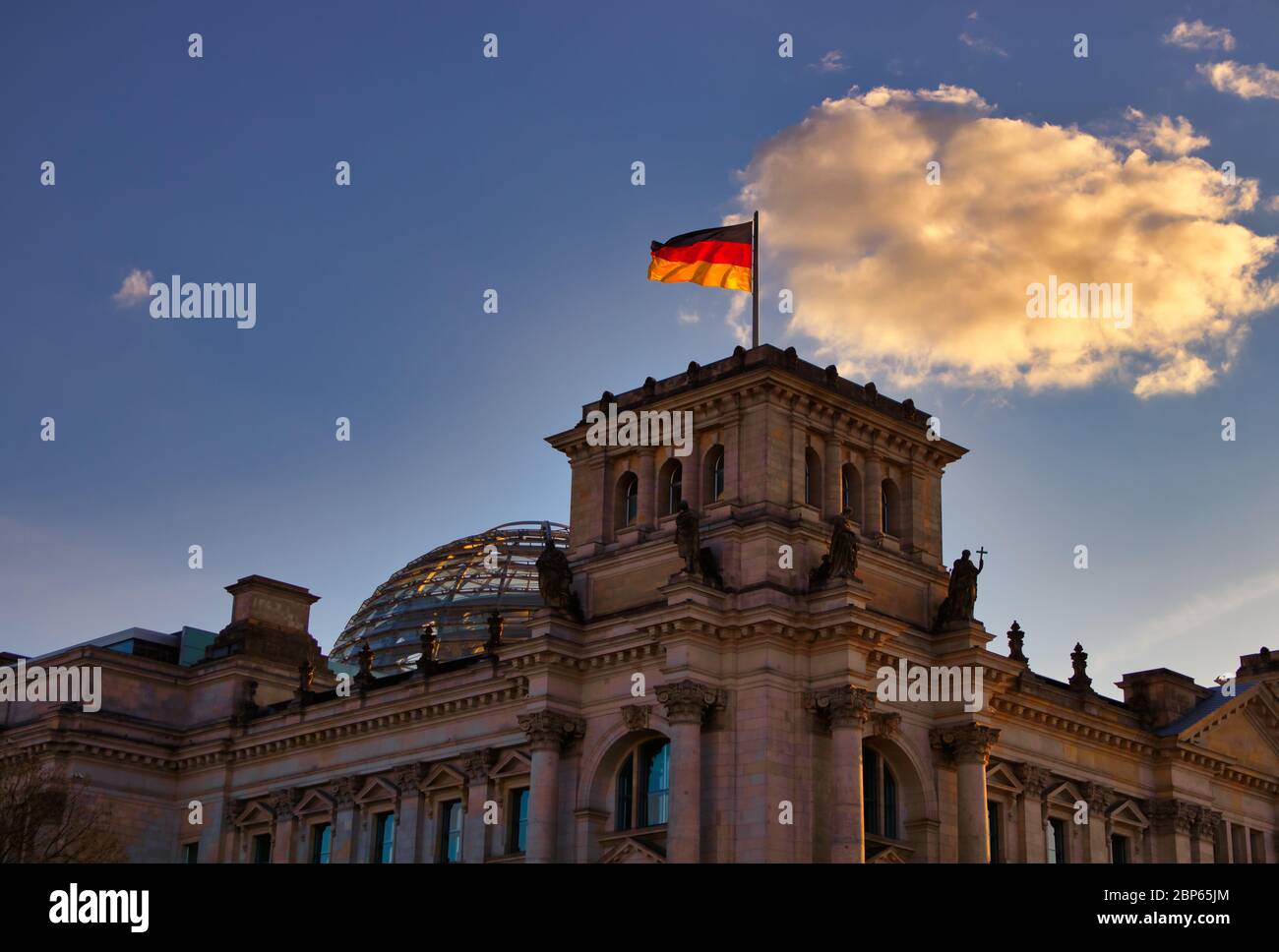The famous Reichstag building in Berlin, seat of the German Bundestag, with a waving flag of the Federal Republic of Germany Stock Photo