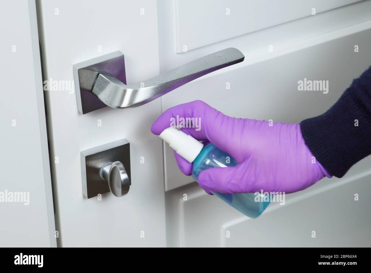 Washing the door handle with a sanitizer. COVID19 Stock Photo Alamy