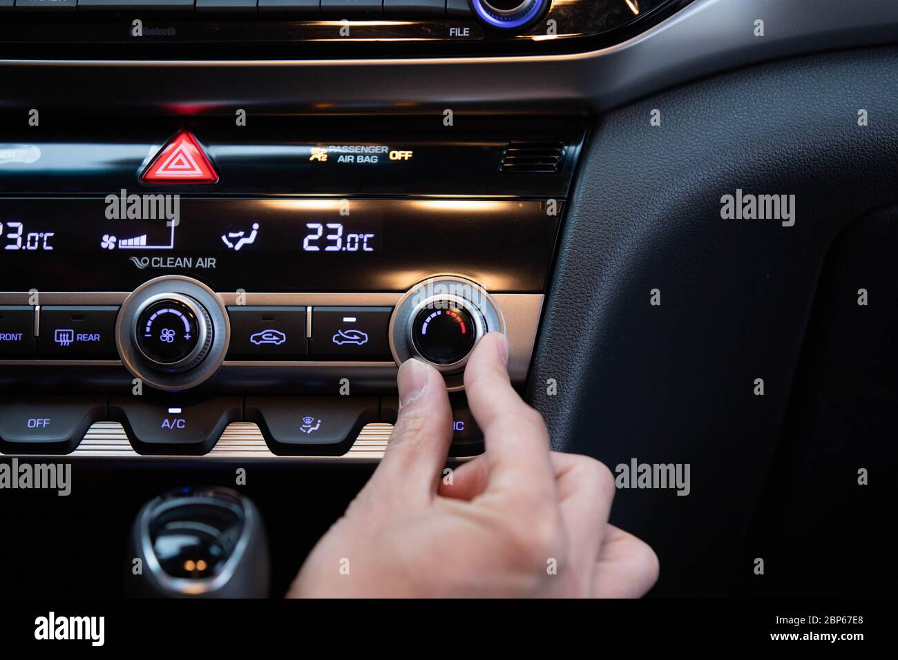 Hand turning on car's air conditioner dial. Hand adjusting heater temperature button. Stock Photo