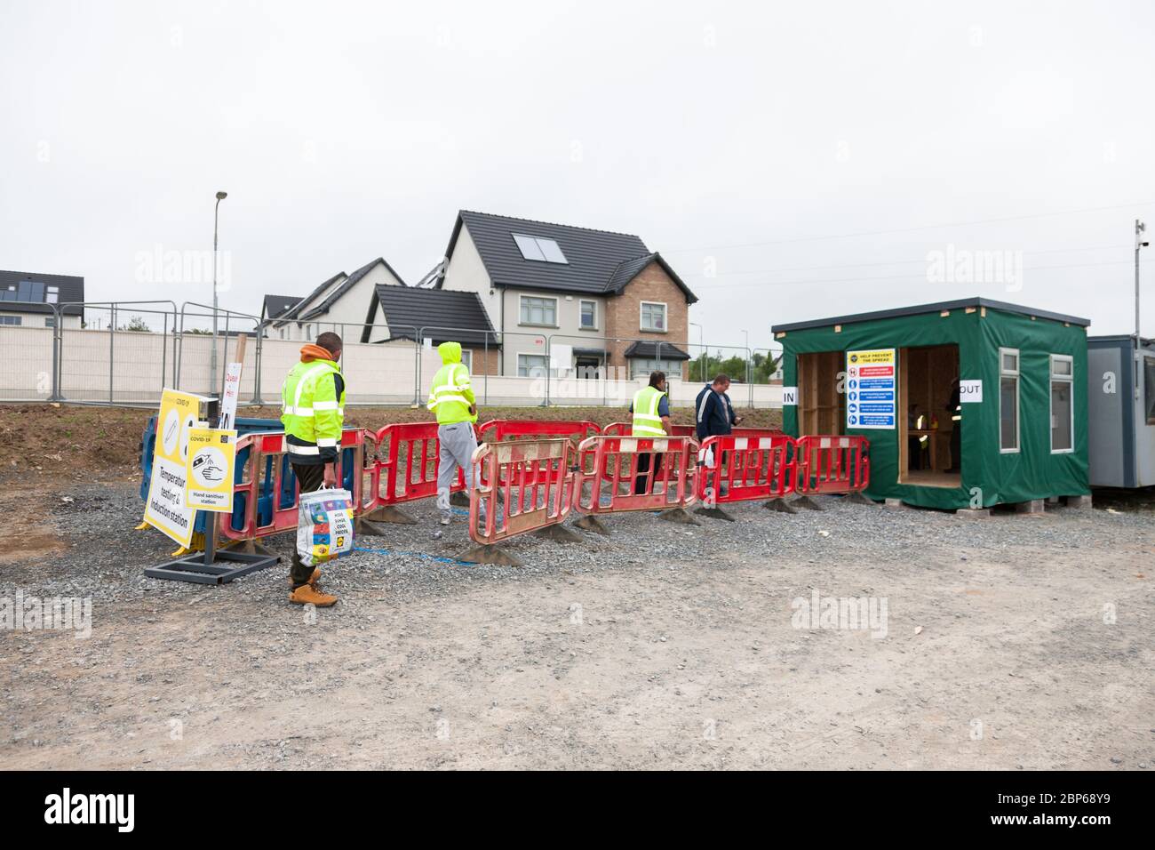 Carrigaline, Cork, Ireland. 18th May, 2020.On the first day of phase one with the easing of Covid-19 restrictions works queue at the temperature testiong station at the Astra construction site in Janeville, Carrigaline, Co. Cork, Ireland. - Credit; David Creedon / Alamy Live News Stock Photo