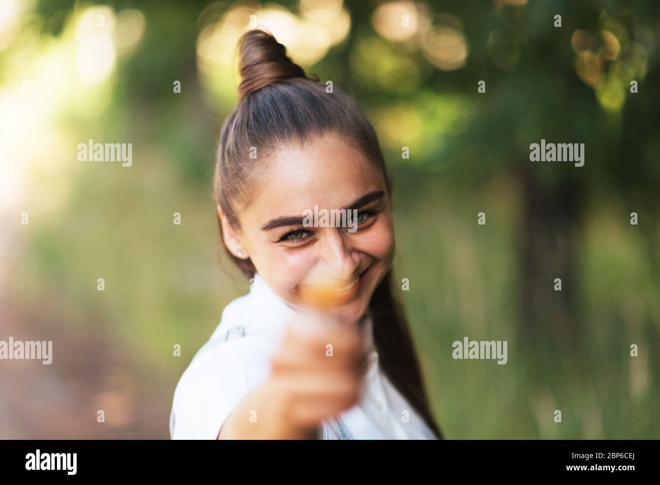 The girl shows the candy on a stick in the frame.  Stock Photo