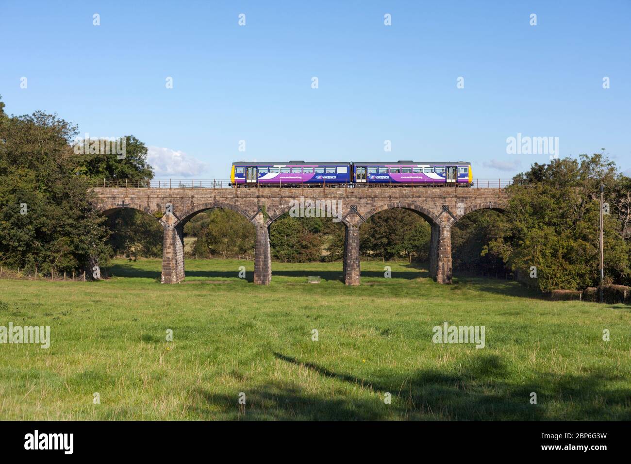 Northern Rail class 142 pacer train crossing the arch viaduct at Capenwray on the scenic 'little north western' railway line in Lancashire Stock Photo
