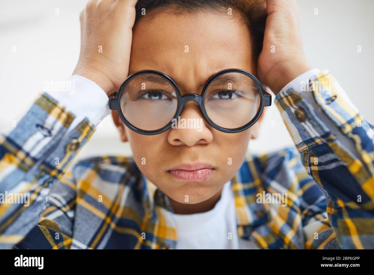 Close up of cute African boy wearing big glasses frowning and pouting while looking at camera Stock Photo Alamy