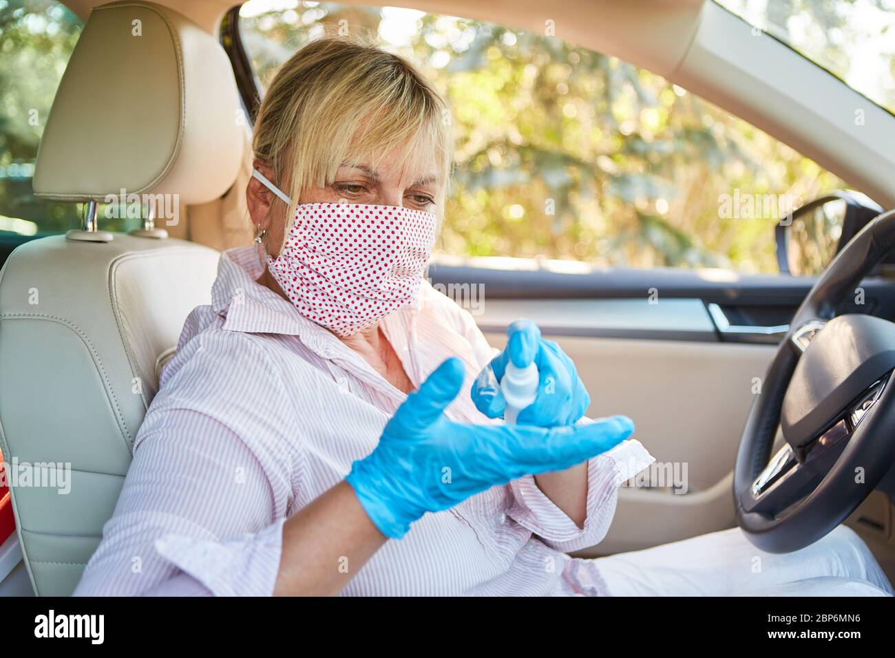 Cleaner with face mask uses disinfectants in rental cars because of