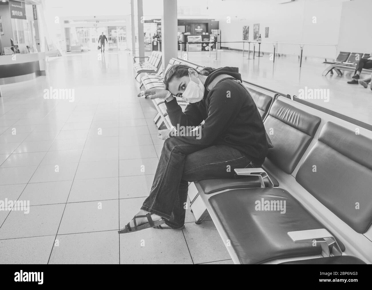 COVID-19 Pandemic restrictions. Young woman waiting at the airport to return home city after being stuck in a foreign country as governments have rest Stock Photo