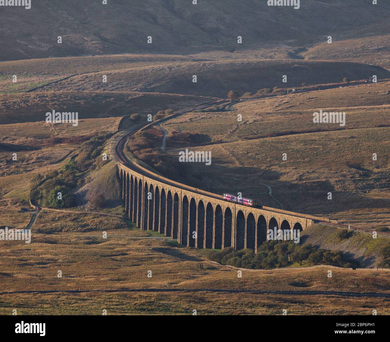 Arriva Northern rail class 158 sprinter train crossing Ribblehead viaduct surrounded by the Yorkshire dales countryside Stock Photo