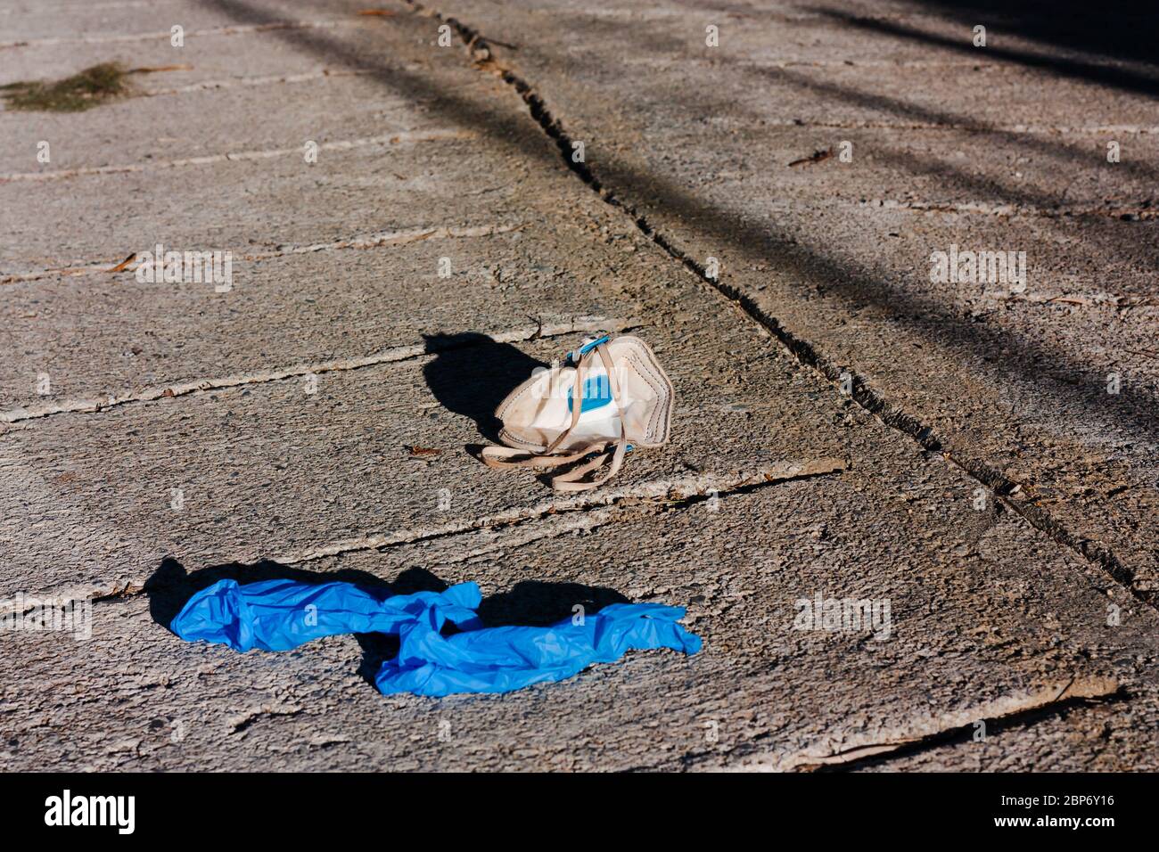 Surgical masks and gloves discarded on the street. Waste disposal