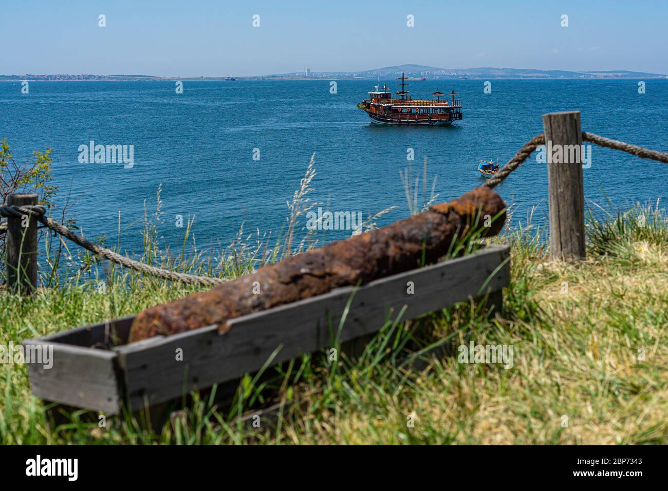 ST. ANASTASIA ISLAND, BULGARIA - JUNE 23, 2019: Pleasure boat in the Burgas Bay of the Black Sea. Sea view from the side of the island of St. Anastasia. In the foreground is an old cannon. Stock Photo