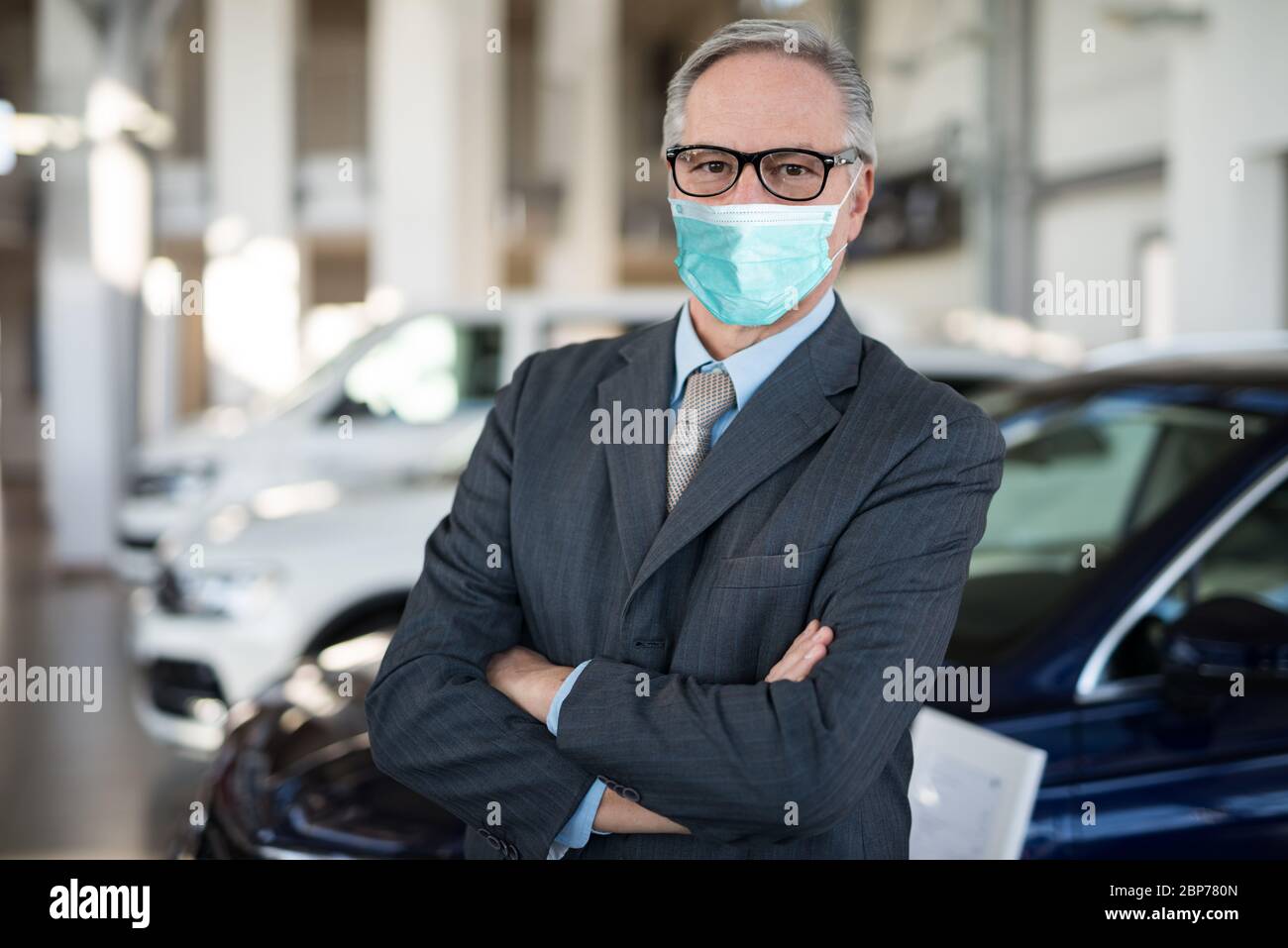 Masked car dealer principal inside showroom during coronavirus pandemic