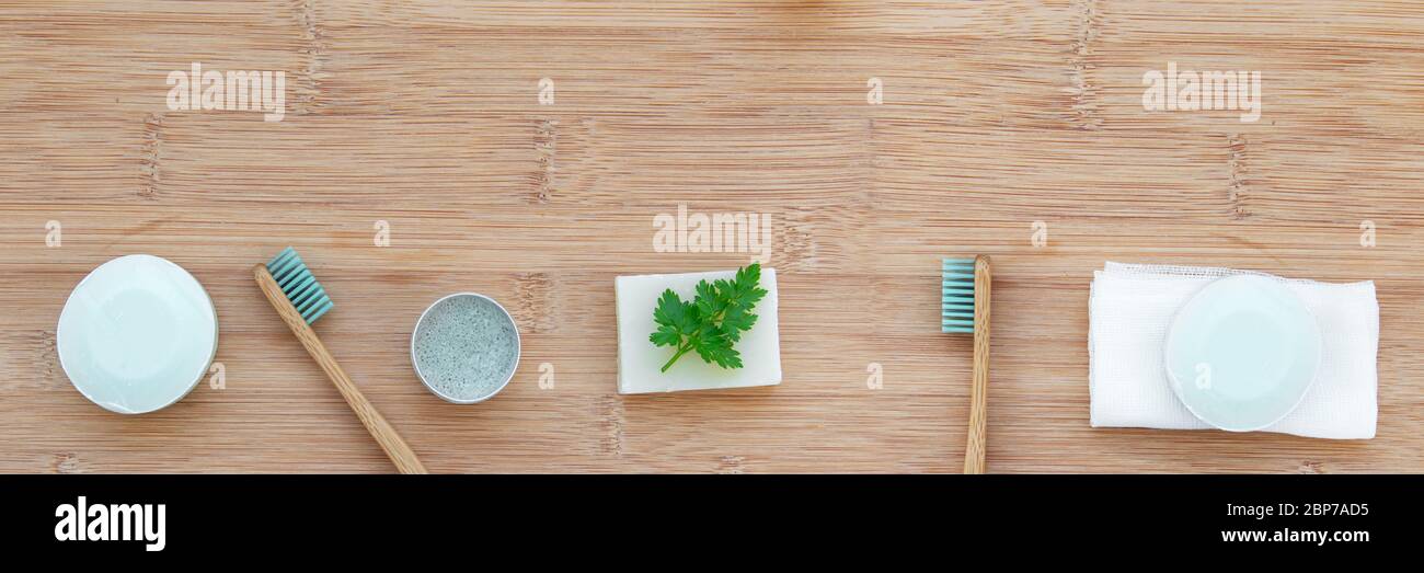 Zero waste bathroom web banner with copy space. Bamboo toothbrushes, solid toothpaste, solid shampoo and soap on wood background. Plastic free, enviro Stock Photo