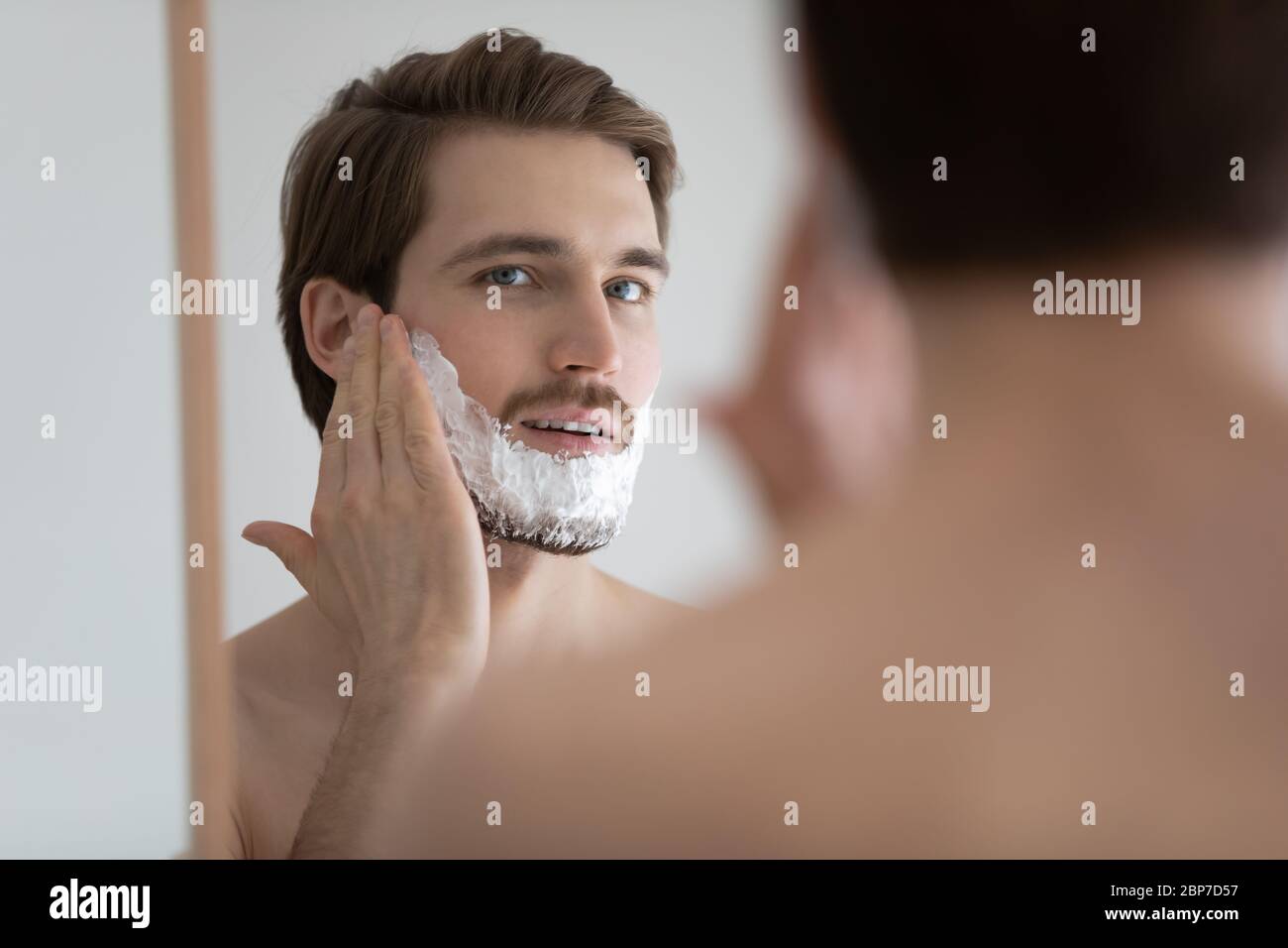 Young man apply foam shaving in bathroom Stock Photo Alamy