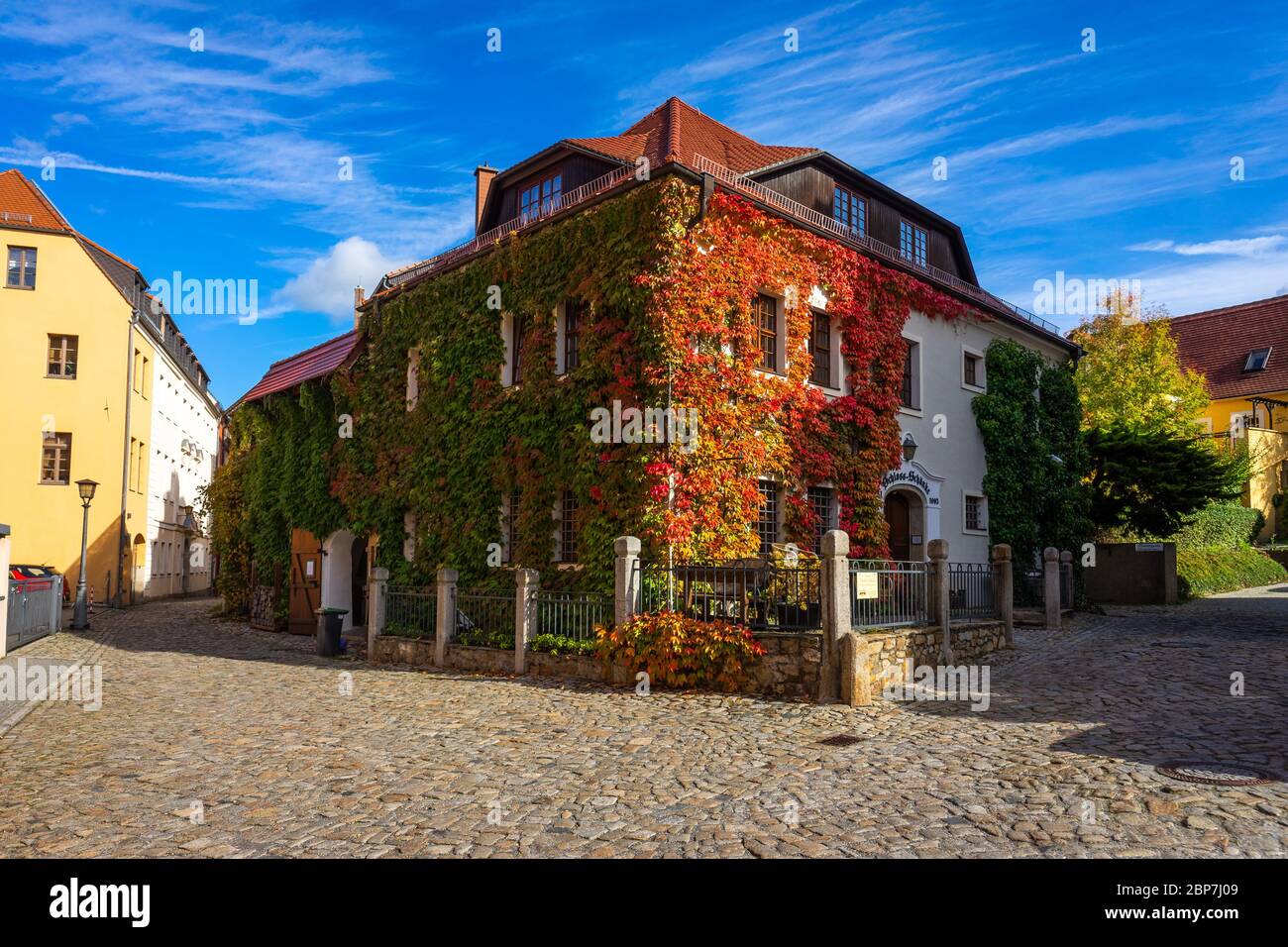 BAUTZEN, GERMANY - OCTOBER 10, 2019: Beautiful streets of the historical part of the old town in a fall day. A house twined with ivy. Stock Photo