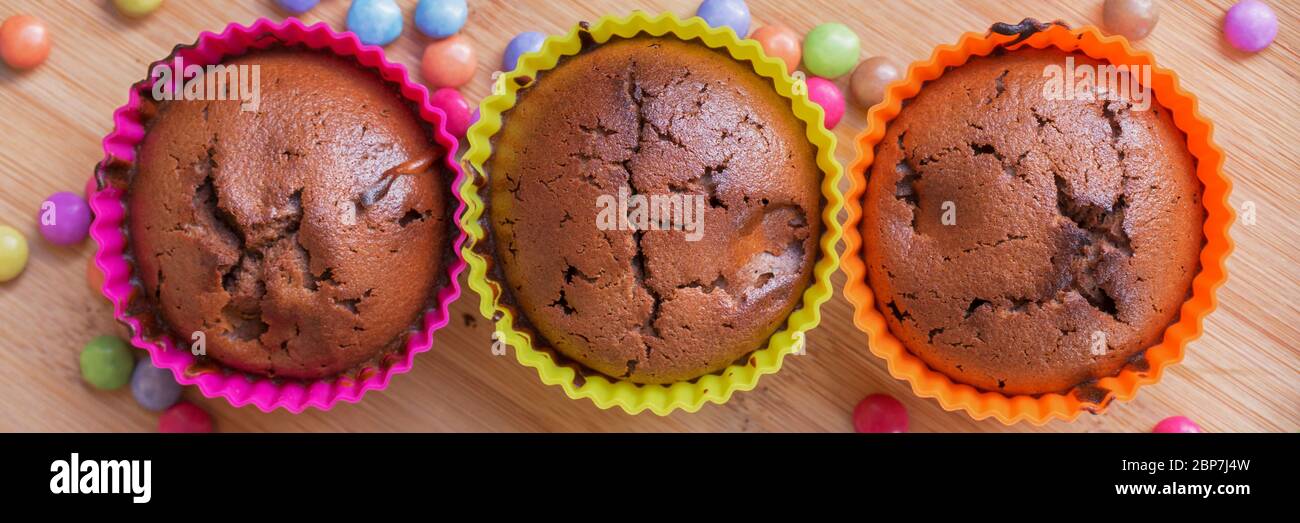 Colorful chocolate cupcakes with sweets, panoramic food web banner Stock Photo