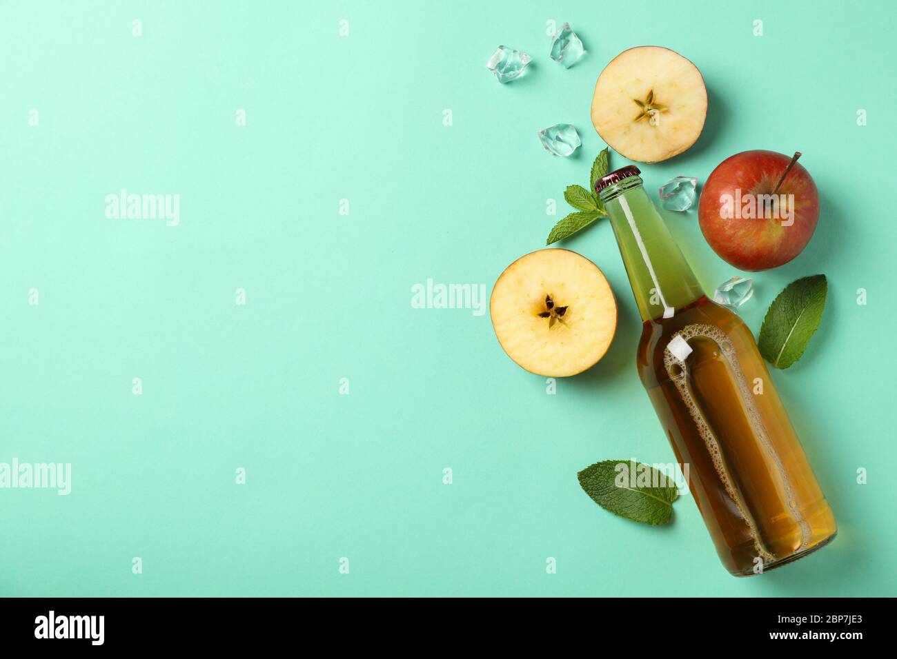 Composition with cider, apples and ice on mint background Stock Photo