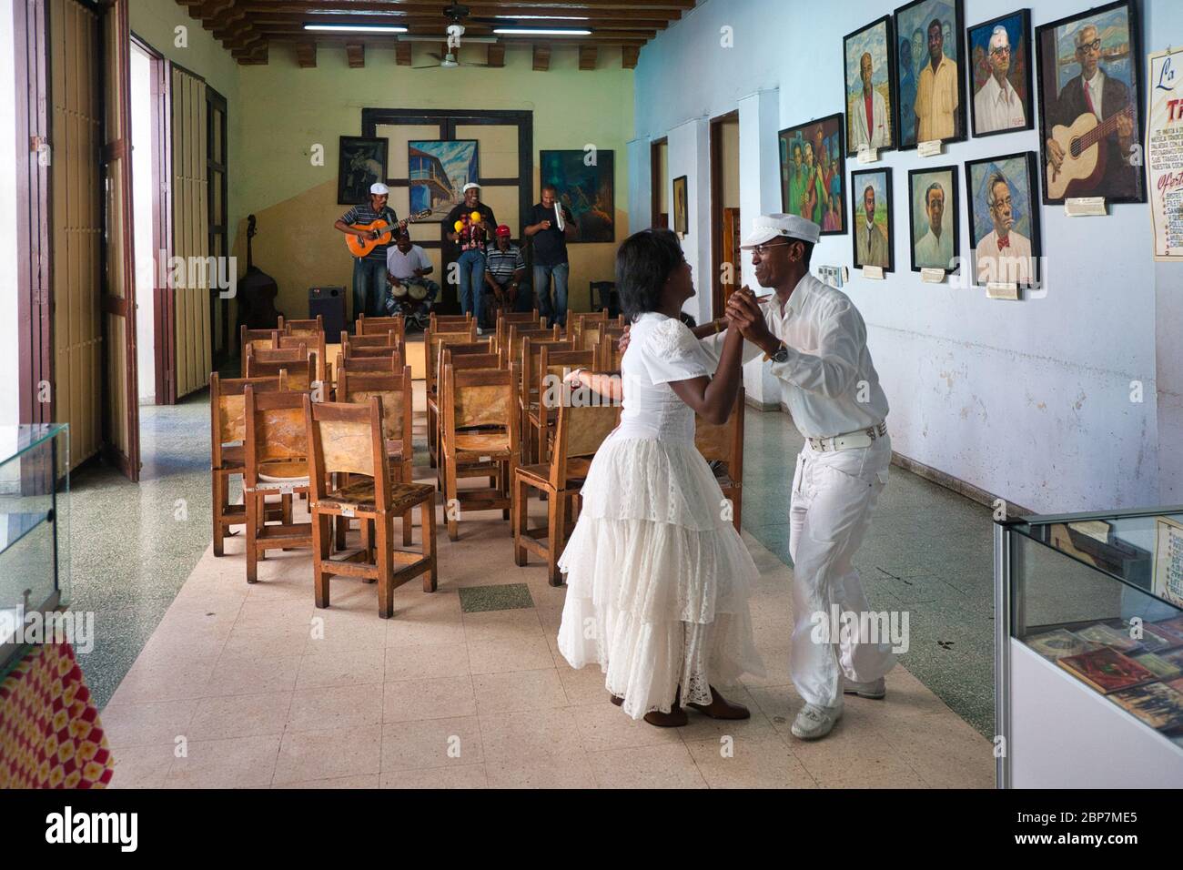 A local couple do an impromptu dance to the music of musicians in a coffee house in Havana, Cuba Stock Photo