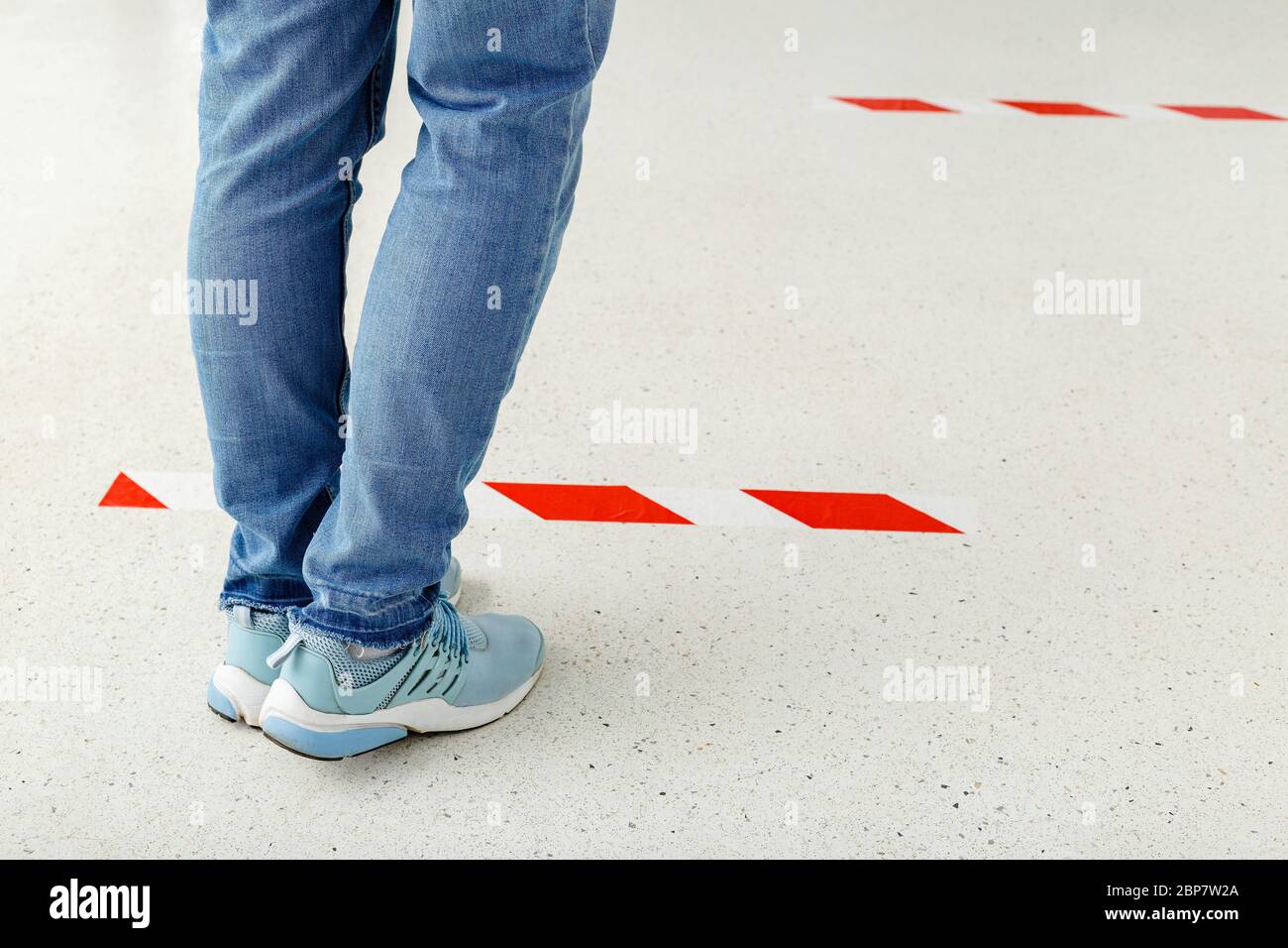 Man stand in line keeping social distance, People standing behind a warning line during covid 19 coronavirus quarantine. Safe shopping, Social Stock Photo