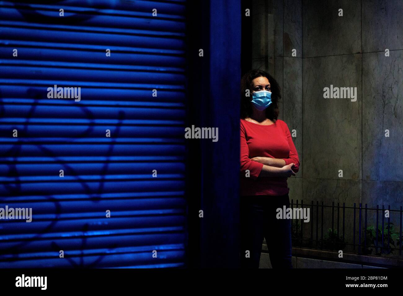 A woman watches as an elderly person suspected of having Corovid-19 is treated by healthcare workers. Stock Photo