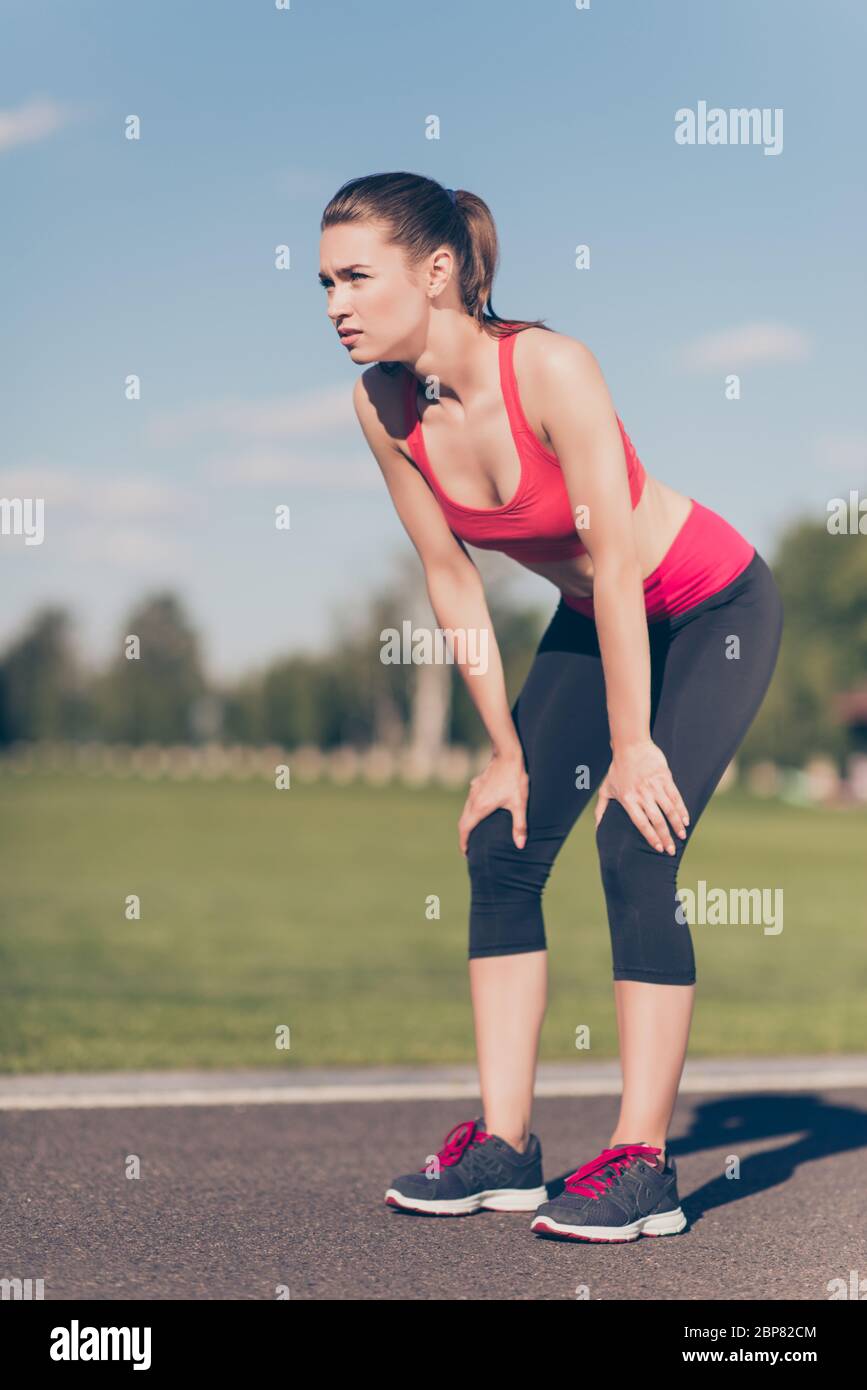 Young lady athlete is training for marathon run. Beautiful fitness model,  in fasionable sports outfit, outdoors in a summer stadium, so focused, fit  a Stock Photo - Alamy