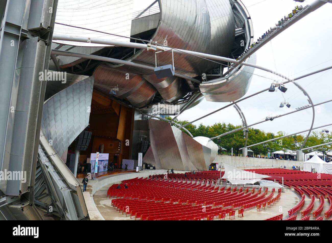 Rows of red chairs in Millennium Park Jay Pritzker Pavilion in downtown Chicago, Illinois, USA Stock Photo