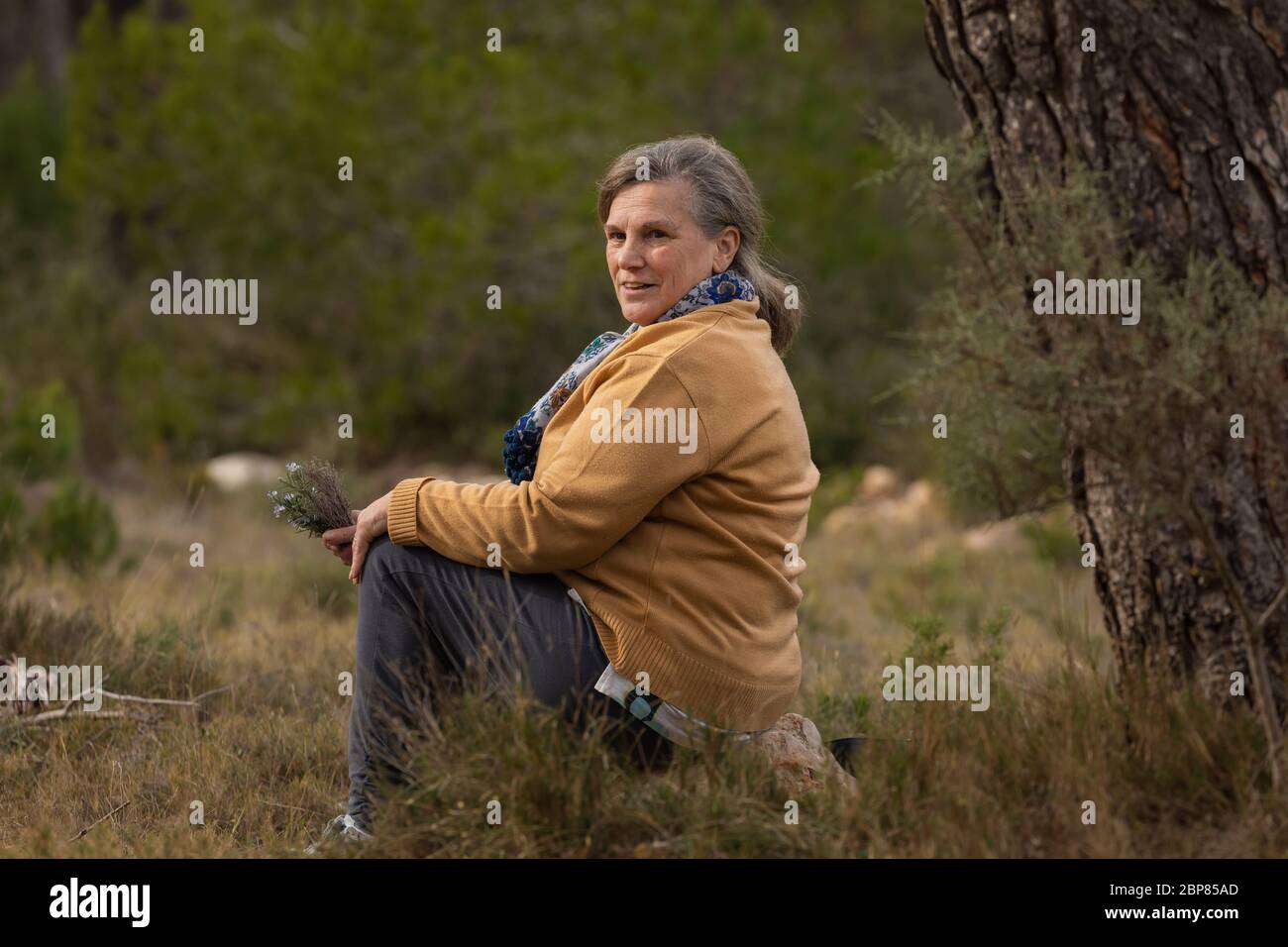 Senior woman rests sitting after a walk in the Sanctuary of Mercy, near Borja, in the province of Zaragoza, Spain. Stock Photo