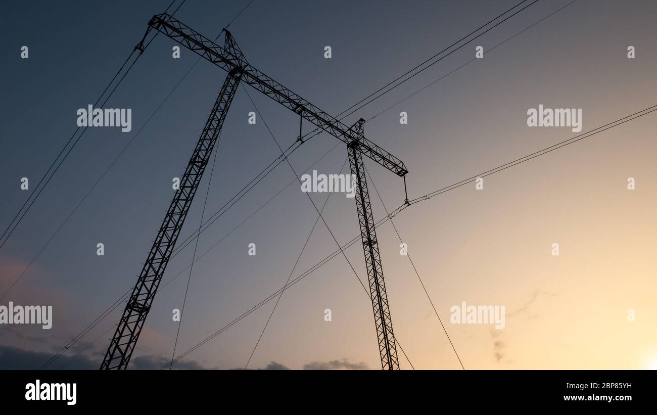 Silhouette of high voltage electric power tower at beautiful sunset ...