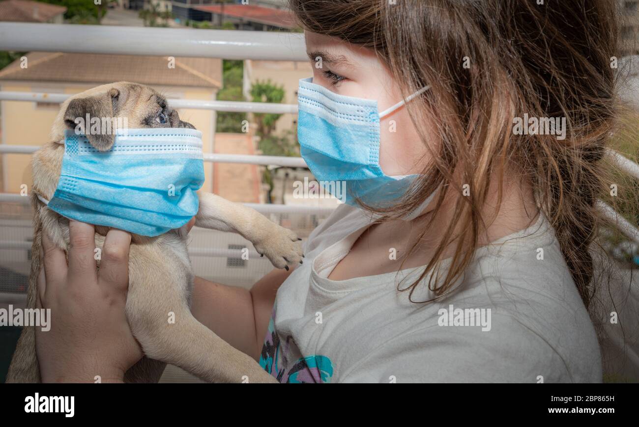 Kid and her pet wearing their masks Stock Photo Alamy