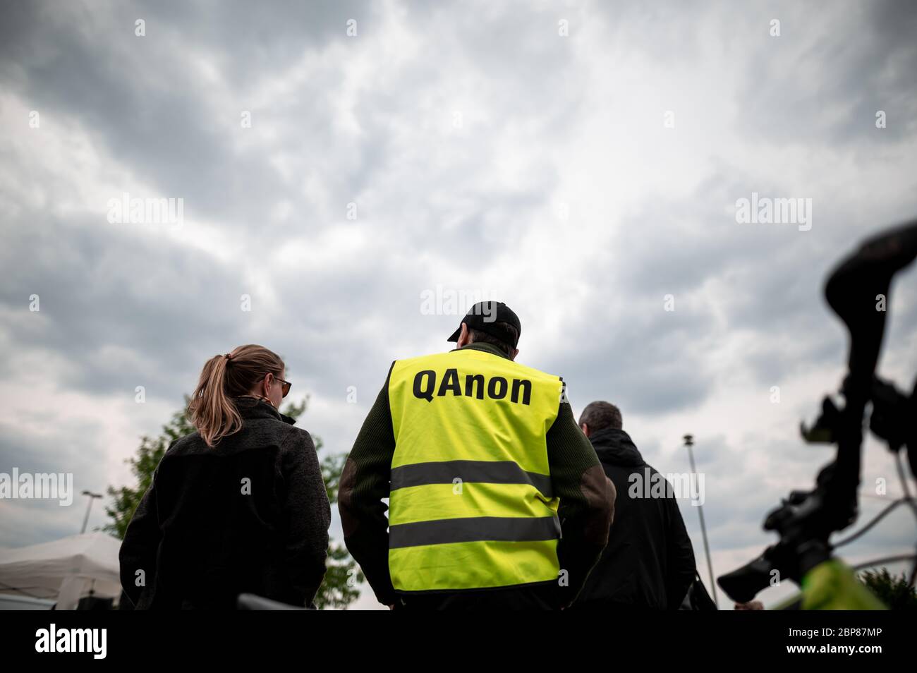 Essen, Germany. 16th May, 2020. A participant of the demonstrations against corona measures wears a warning vest with 'QAnon' written on it. In several cities demonstrations with 500 to 1000 participants are announced - among others in Essen and Dortmund. The police is on duty. The demonstration in Cologne was cancelled. Credit: Fabian Strauch/dpa/Alamy Live News Stock Photo