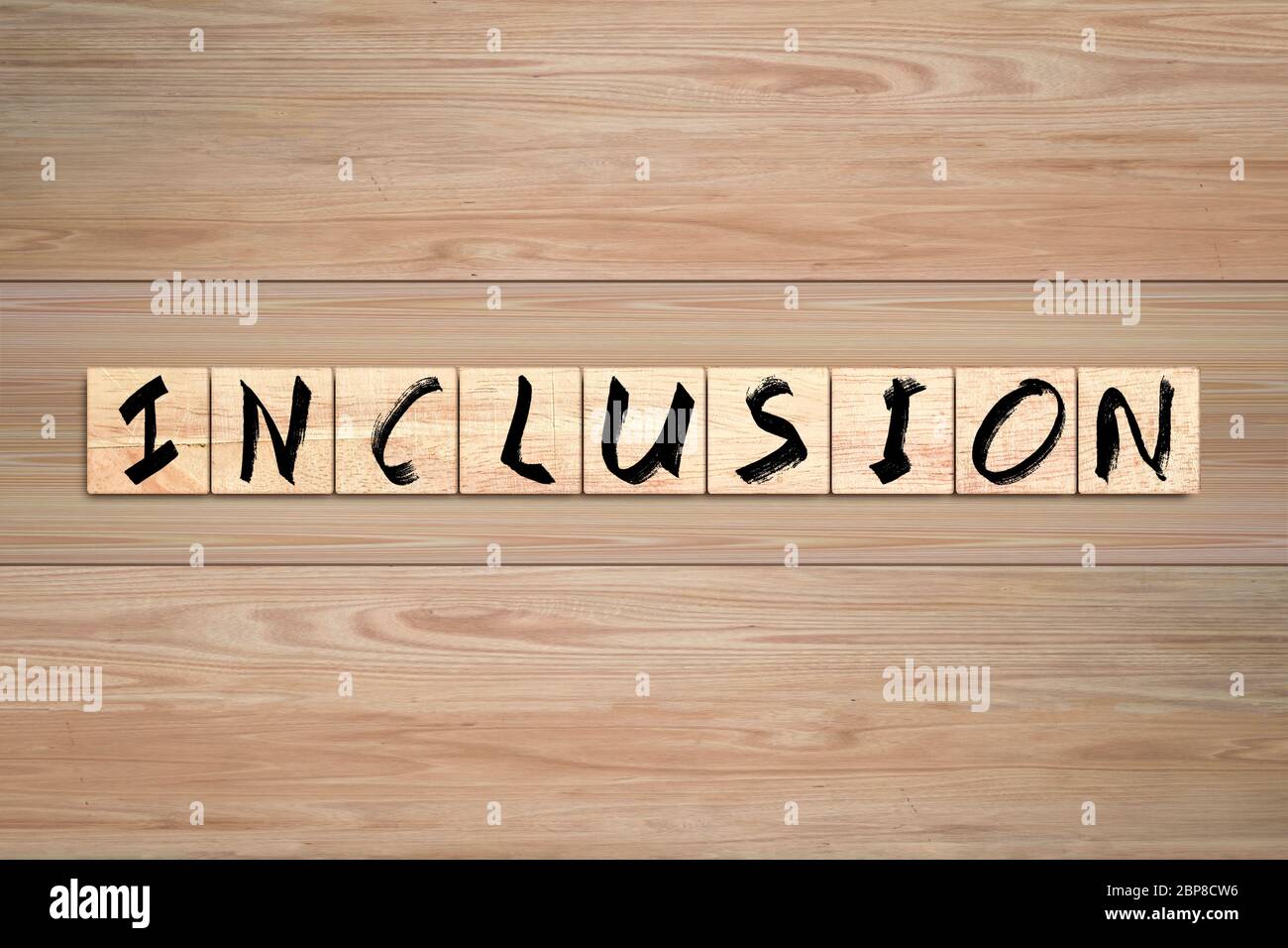 Inclusion word written on wood box. Text on wooden table. Stock Photo
