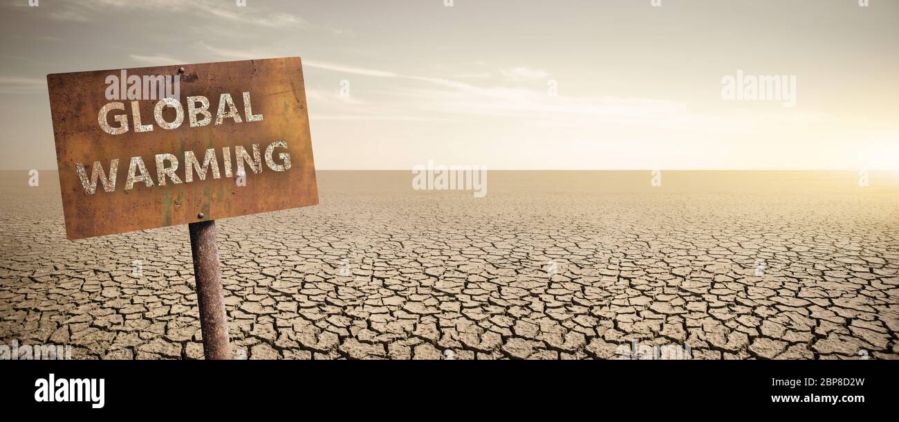 Rusty sign with text 'Global warming' on a background of dry cracked desert. Climate change concept. Stock Photo