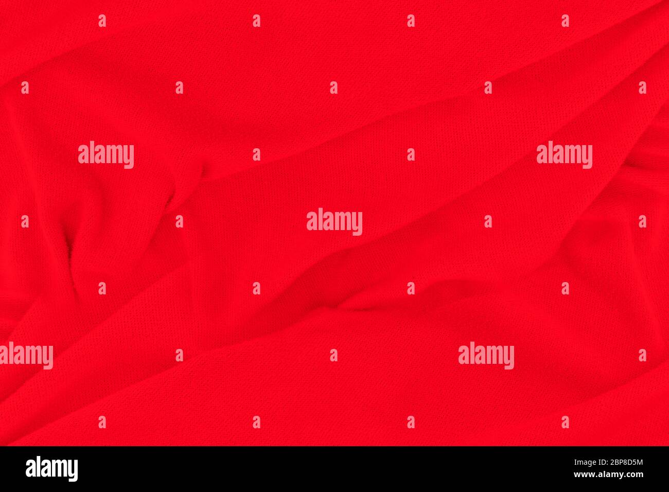 Red fabric texture background. Abstract cloth backdrop with soft waves. Stock Photo