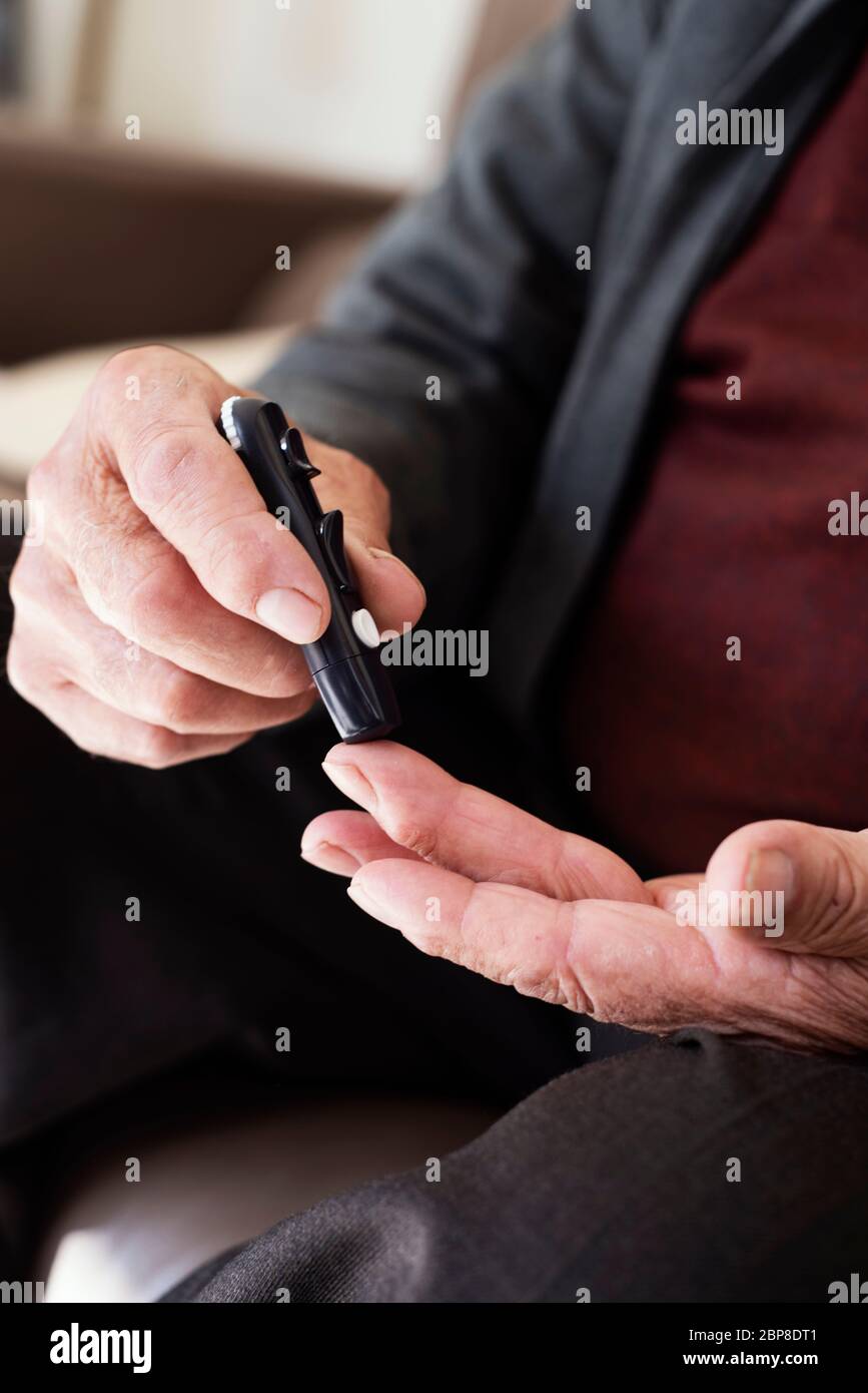 closeup of a caucasian senior man about to measure his blood glucose